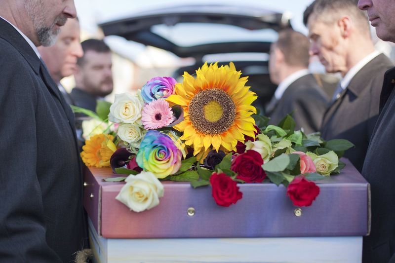 Rainbow roses and a sunflower on a coffin