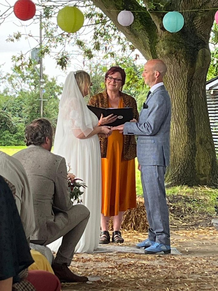 A couple marrying under an oak hung with paper lanterns