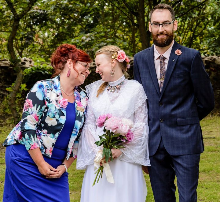 Roxanne laughing with a newly married couple on the lawn