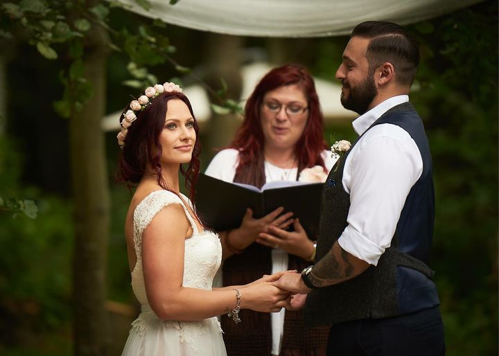 A couple exchanging vows at dusk under fairy lights