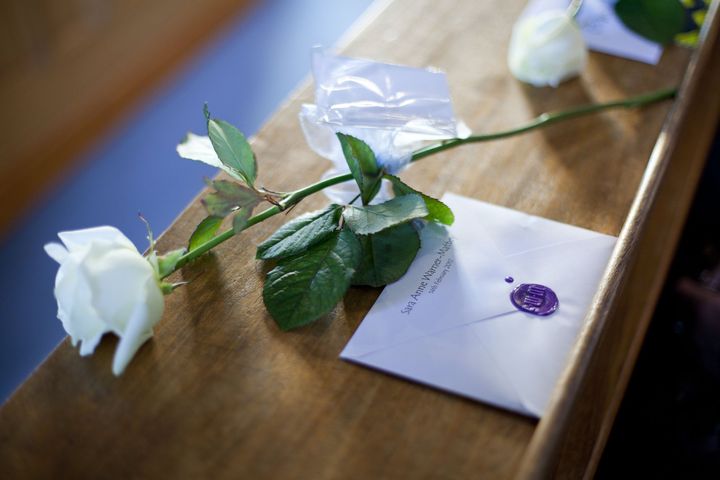 A single white rose resting on an order of service
